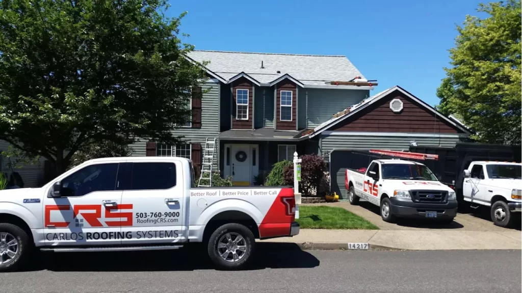 Certified Roofing Systems work trucks parked in front of a two-story house during a roof replacement.